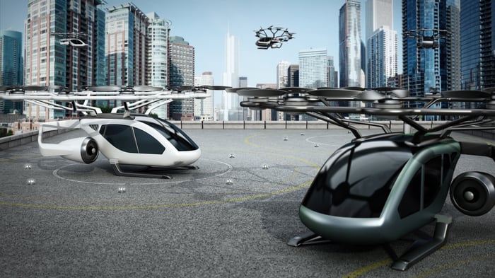 Electric futuristic aircraft perched on a roof.