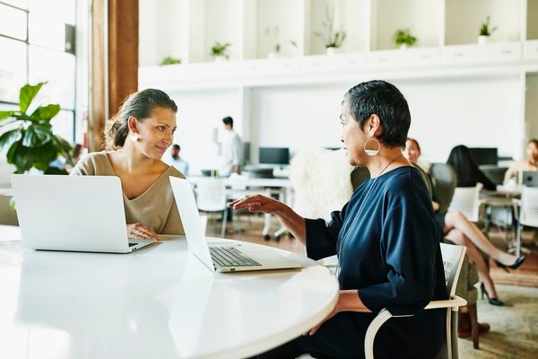 Businesspeople meeting in large open office area.