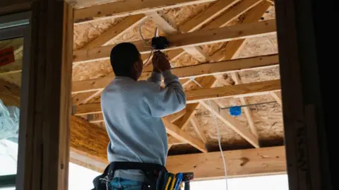 Getty Images  worker installs electrical wiring in a home under construction in Kyle, Texas, US, on Monday, March 18, 2024.