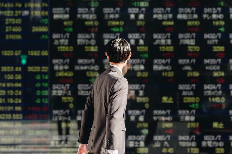 Viewing the stock board displayed on the electronic bulletin board in the business district