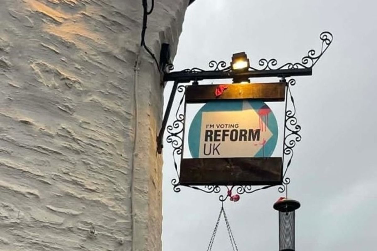 Reform UK sign with red paint splatter 