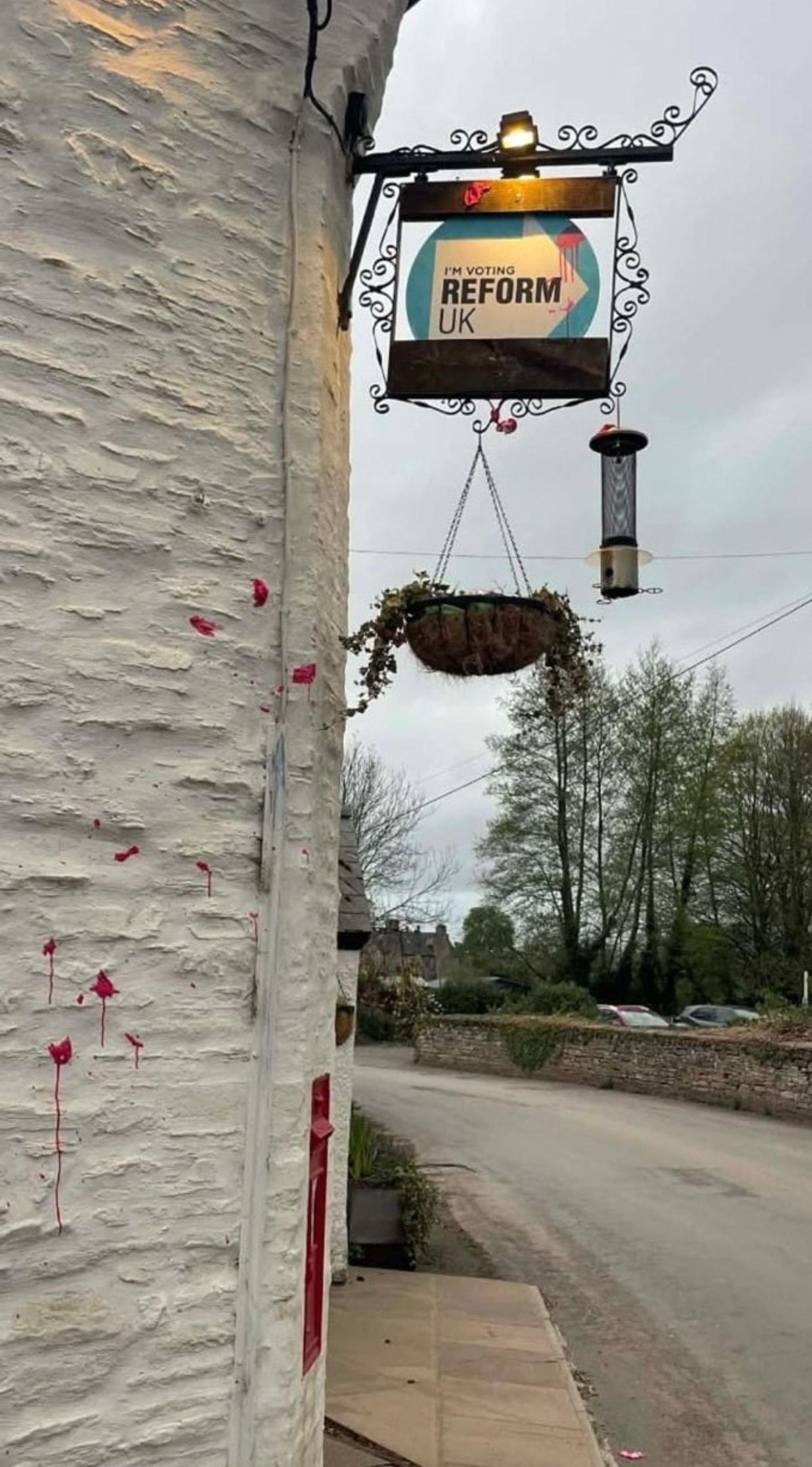 Reform UK sign with red paint splatter 